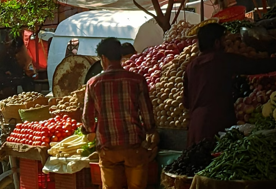 Men looking at potatoes on market stall in Bangladesh