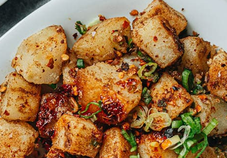 Chinese sauteed potatoes and spring onions on plate