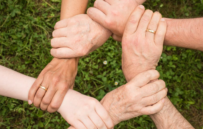 Six joined hands forming a hexagon, representing collaboration in the potato industry