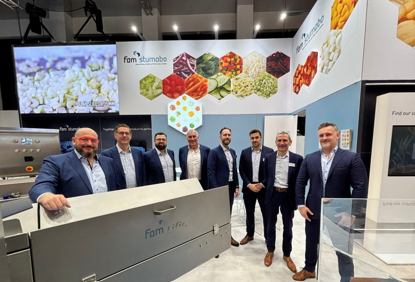 Men standing in front of a cutting machine at a trade show
