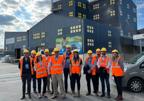 Group of course attendants in high-vis jackets on factory tour