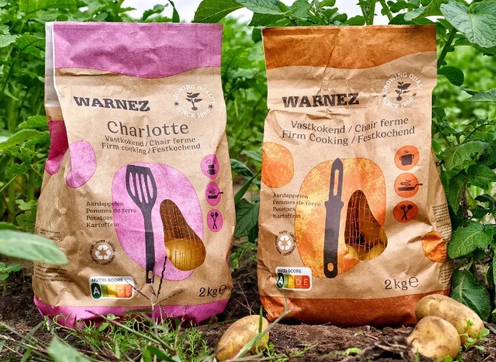 Brown recyclable bags containing potatoes with purple and orange writing on package.