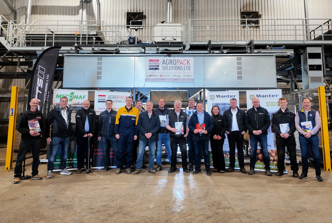Team of people stood in front of machinery in factory