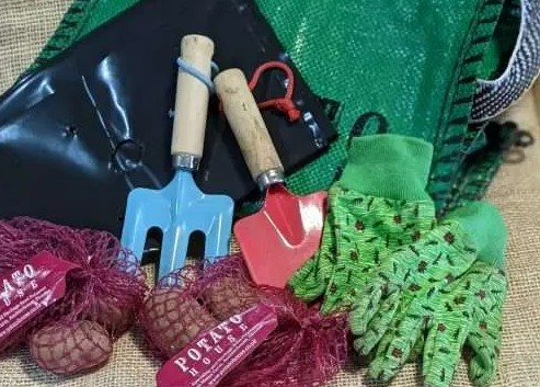 trowel, miniature fork, gardening gloves, sack and seed potatoes