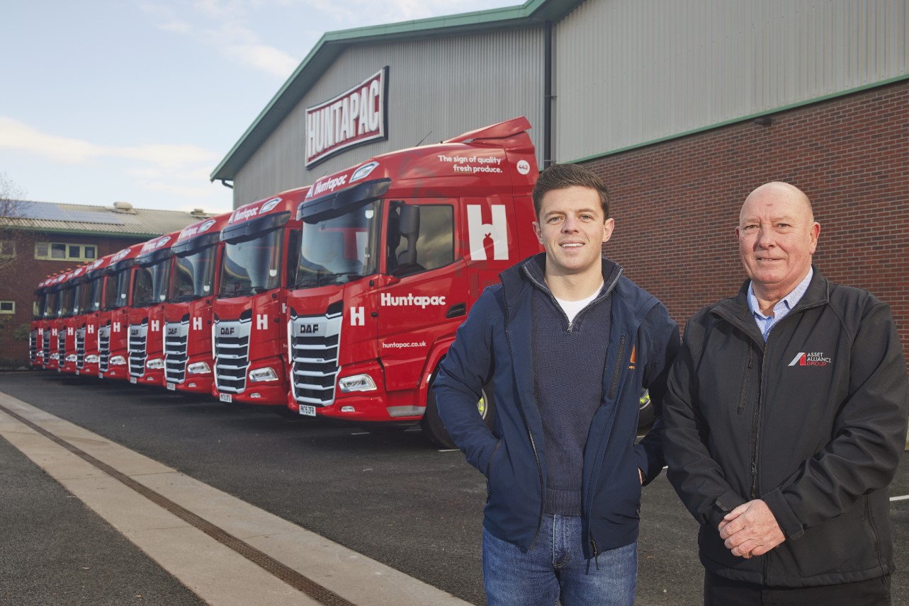Fleet of new red trucks with two men in foreground