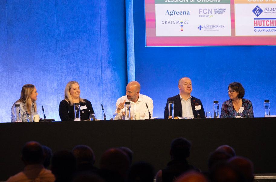 Panelists behind front table at conference