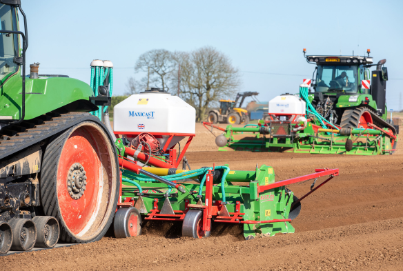 Tractor with implement on back applying a nematicide to potato crops