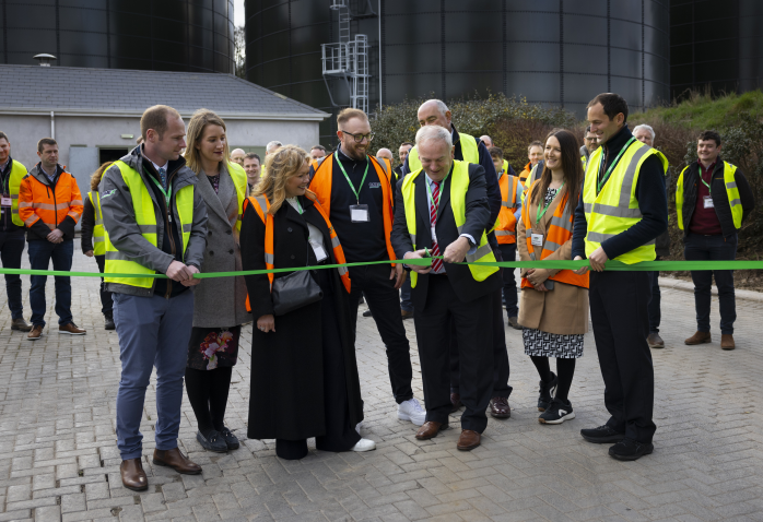 people in hi-viz vests cutting a ribbon to mark opening of new distribution hub