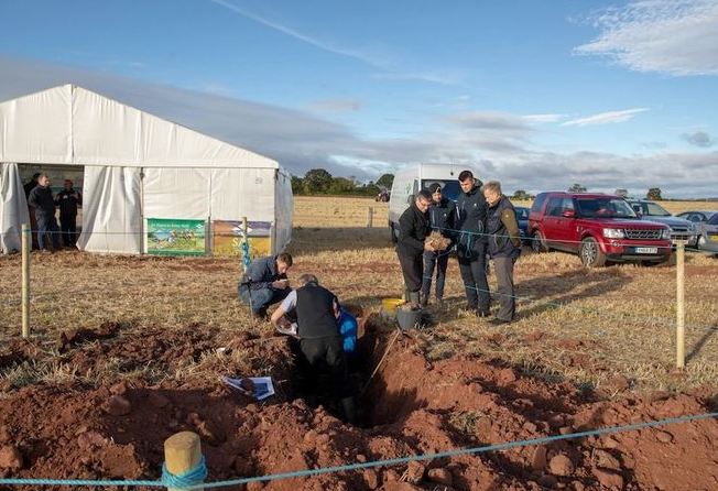 A soil knowledge trail with people gathered round