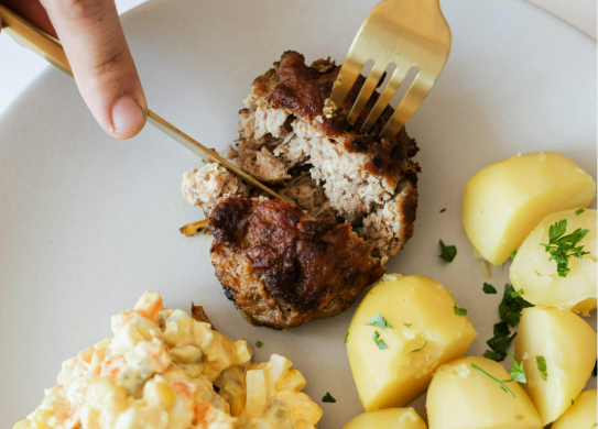 knife and fork eating potatoes and beefburger