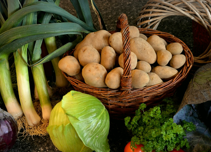 basket of potatoes surrounded by other vegetables