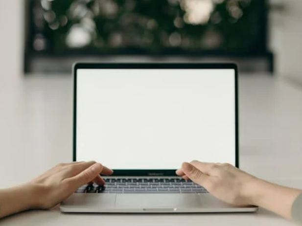 two hands on laptop keyboard filling in online potato assurance survey