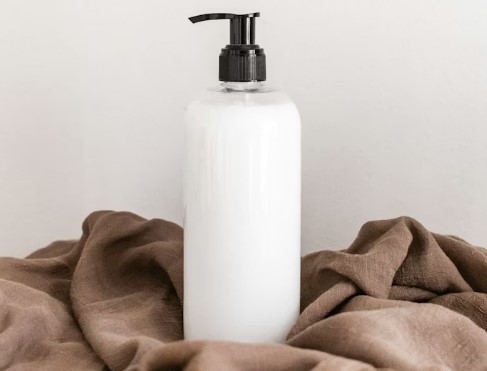 Cosmetic bottle with pump top and white fluid inside