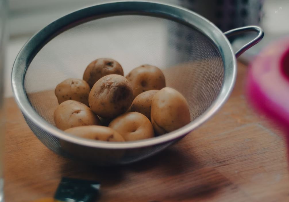 Spanish potatoes in wire sieve